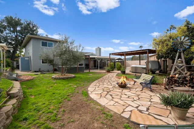 a view of a house with backyard sitting area and garden