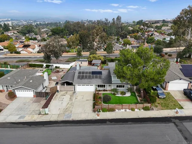 an aerial view of a house with a garden and lake view