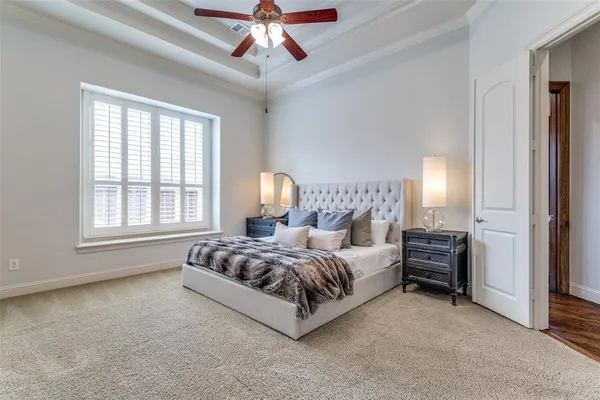 a spacious bedroom with a bed and a chandelier