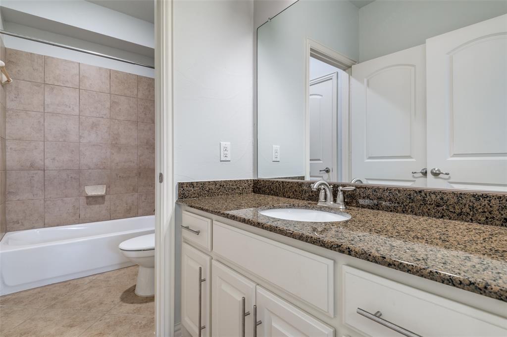 8237 Inverness The Colony, TX 75056 - Photo 17 of 22 a bathroom with a granite countertop sink a toilet and bathtub
