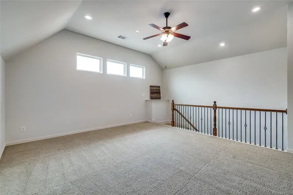 a view of an empty room with a chandelier fan