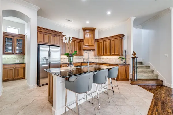 a kitchen with stainless steel appliances granite countertop a sink and a refrigerator