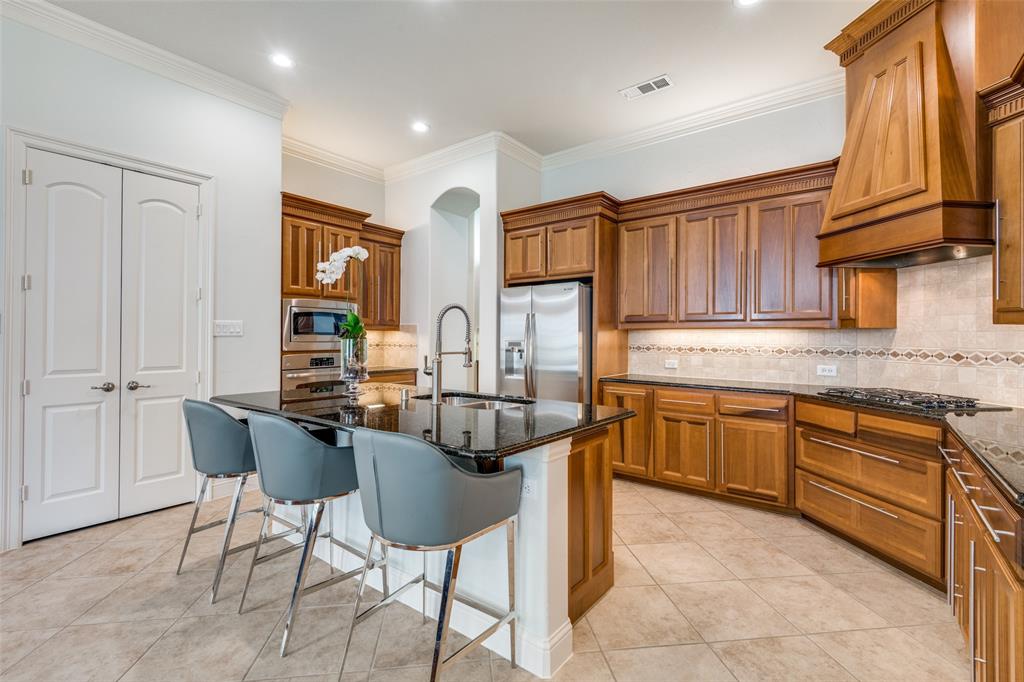 8237 Inverness The Colony, TX 75056 - Photo 7 of 22 a kitchen with stainless steel appliances granite countertop a sink and cabinets
