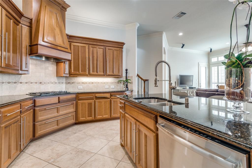 8237 Inverness The Colony, TX 75056 - Photo 9 of 22 a kitchen with kitchen island granite countertop a sink and white cabinets