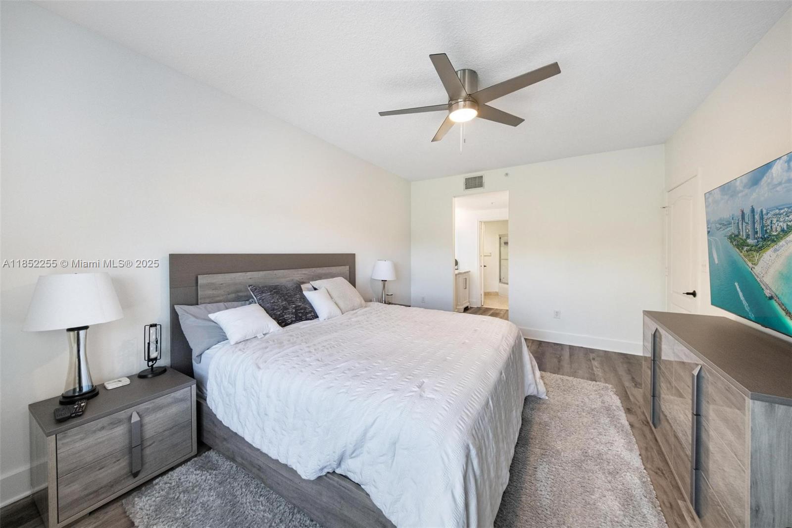 800 Uno Lago Drive, Unit 301 Juno Beach, FL 33408 - Photo 12 of 27 a bedroom with a bed and a potted plant