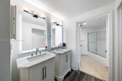 a bedroom with a bed a dresser with wooden floor