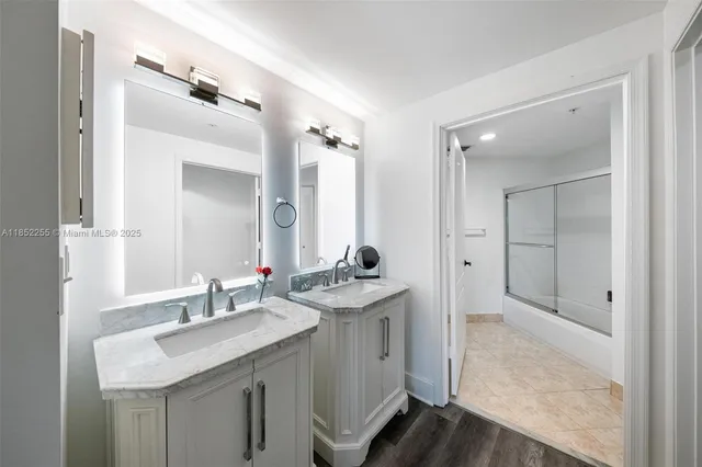 a bedroom with a bed a dresser with wooden floor