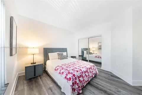 a bedroom with a bed and a lamp on dresser