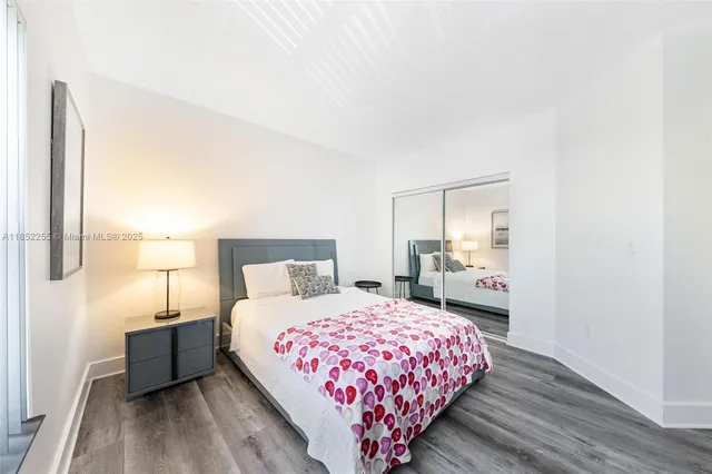 a bedroom with a bed and a lamp on dresser