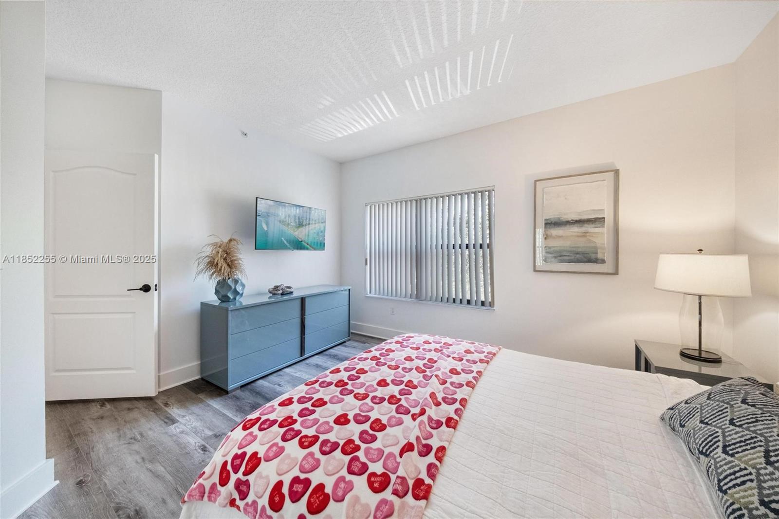 800 Uno Lago Drive, Unit 301 Juno Beach, FL 33408 - Photo 16 of 27 a bedroom with a bed and a lamp on dresser