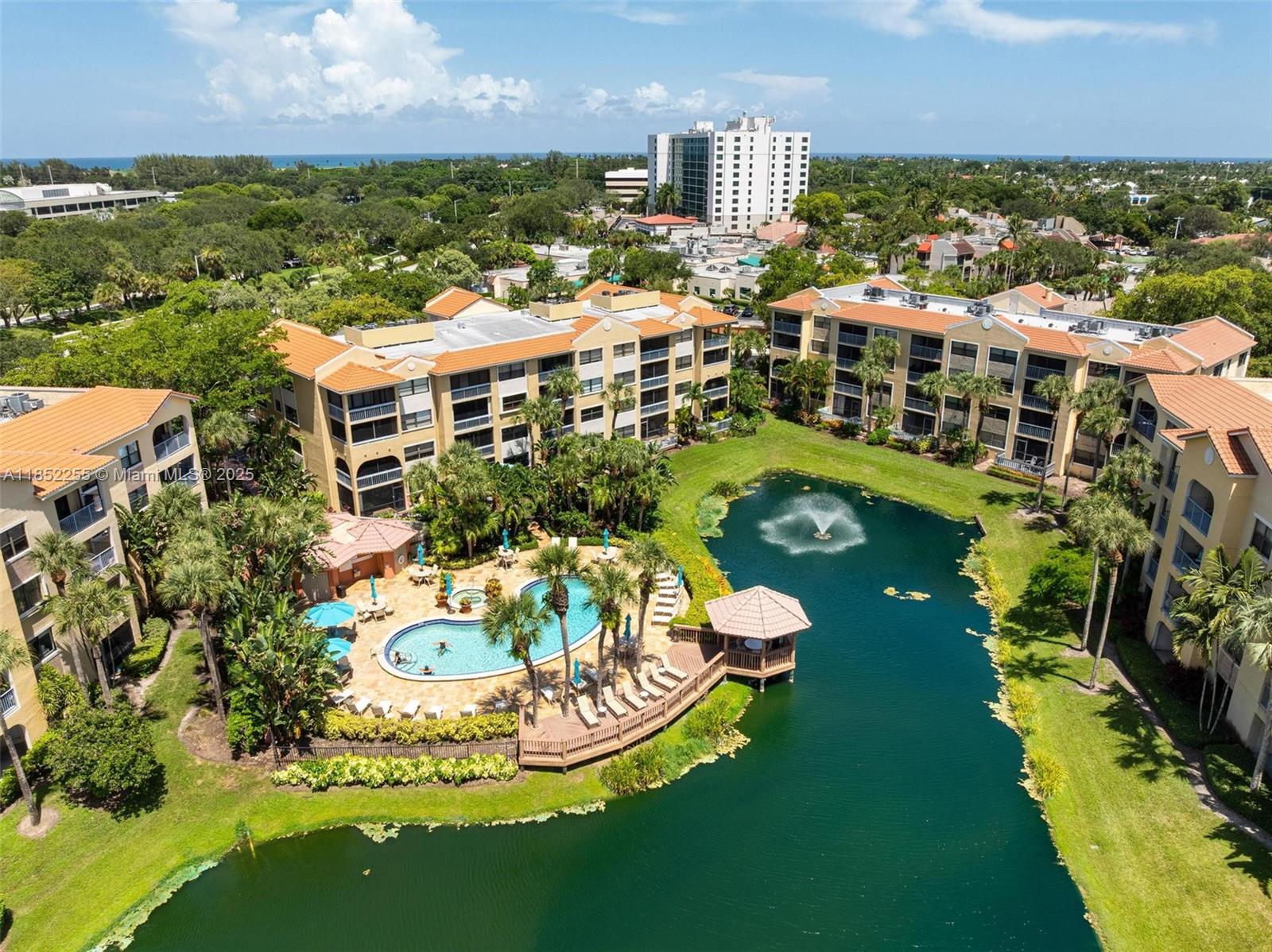 800 Uno Lago Drive, Unit 301 Juno Beach, FL 33408 - Photo 24 of 27 a swimming pool with outdoor seating and lots of trees