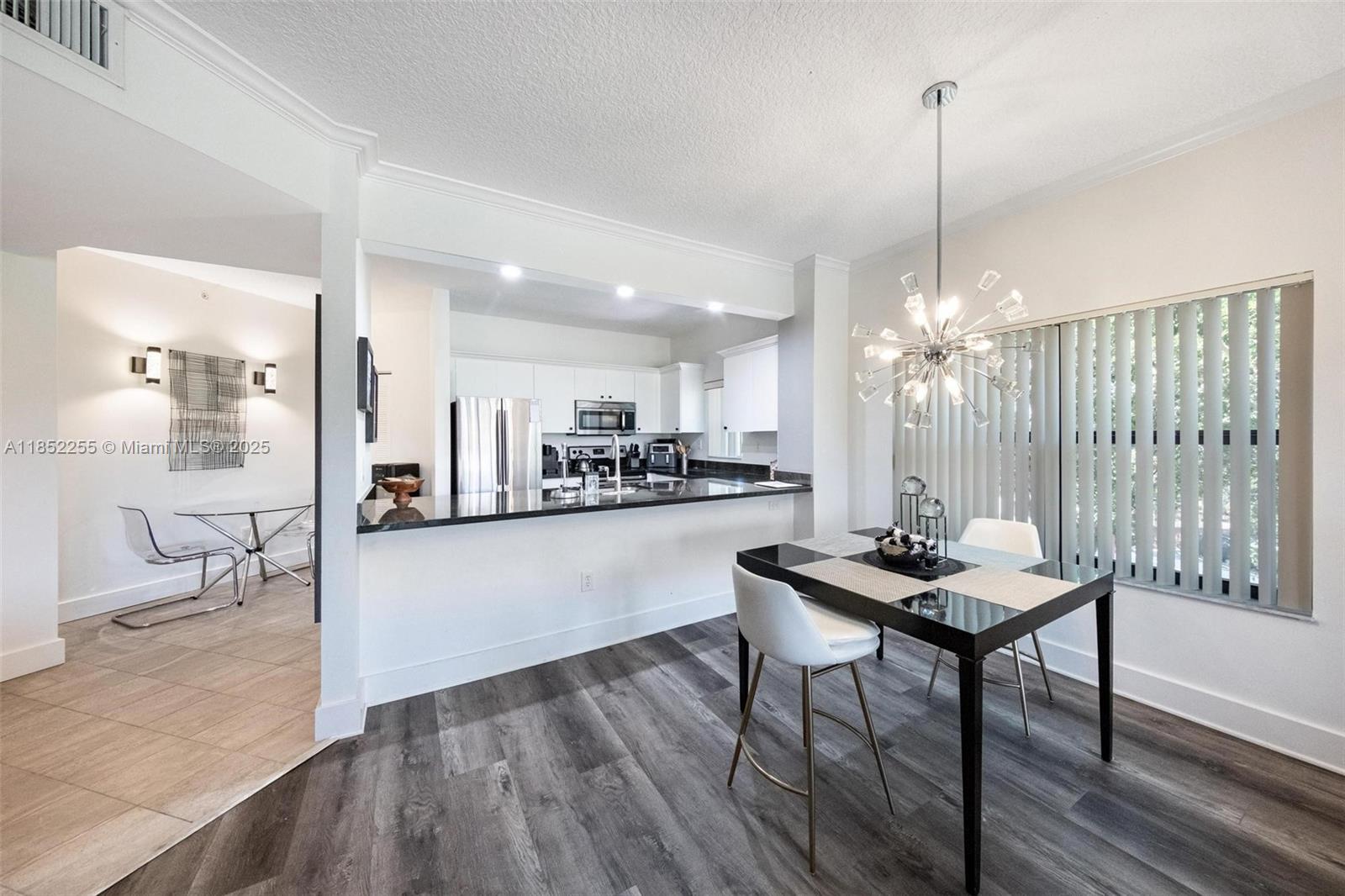 800 Uno Lago Drive, Unit 301 Juno Beach, FL 33408 - Photo 6 of 27 a view of a dining room and livingroom with furniture wooden floor a chandelier