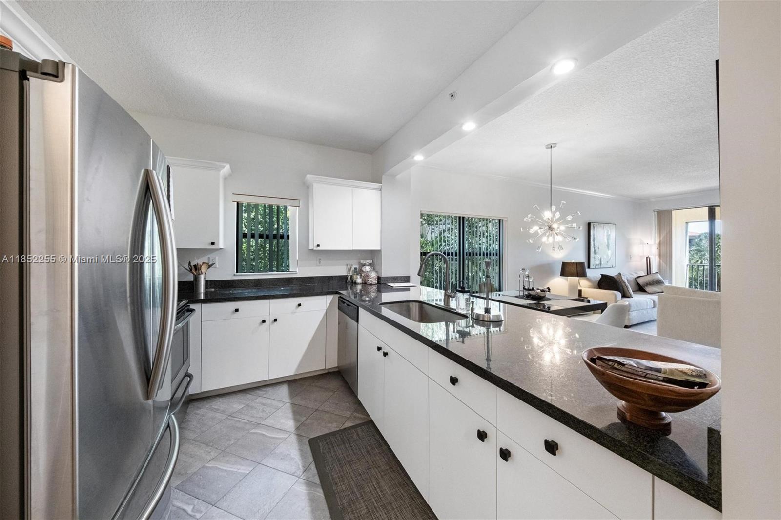 800 Uno Lago Drive, Unit 301 Juno Beach, FL 33408 - Photo 7 of 27 a open kitchen with stainless steel appliances granite countertop a sink a stove and refrigerator