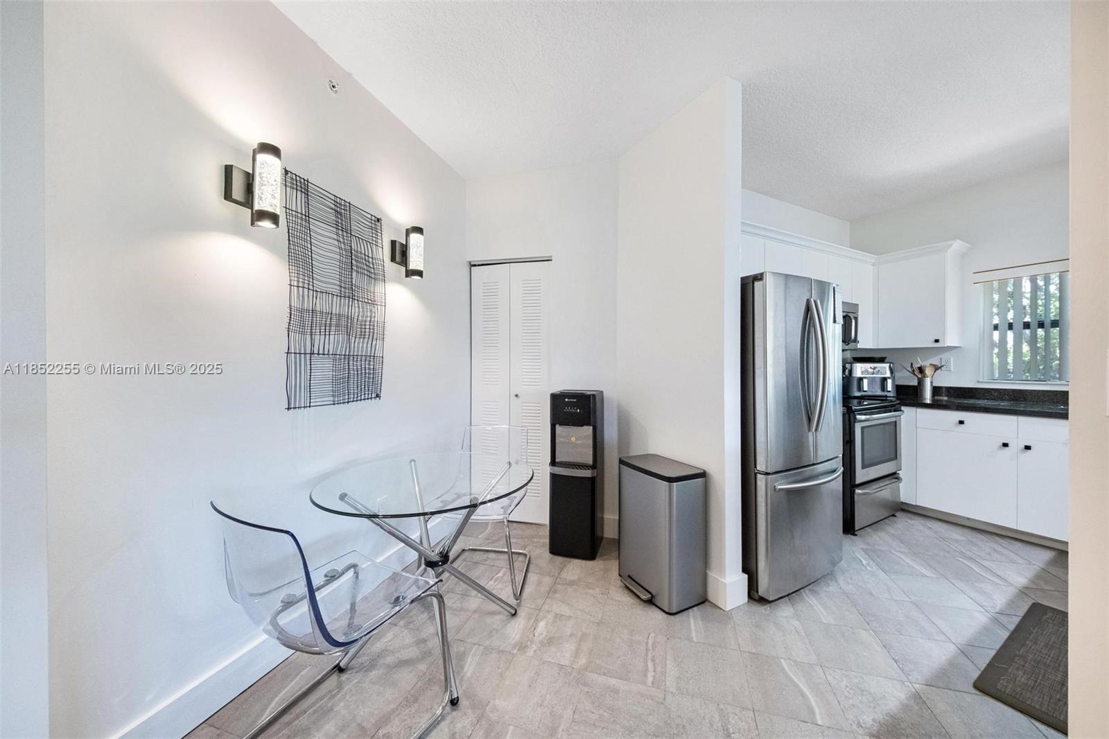800 Uno Lago Drive, Unit 301 Juno Beach, FL 33408 - Photo 9 of 27 a kitchen with stainless steel appliances granite countertop a refrigerator and a stove top oven