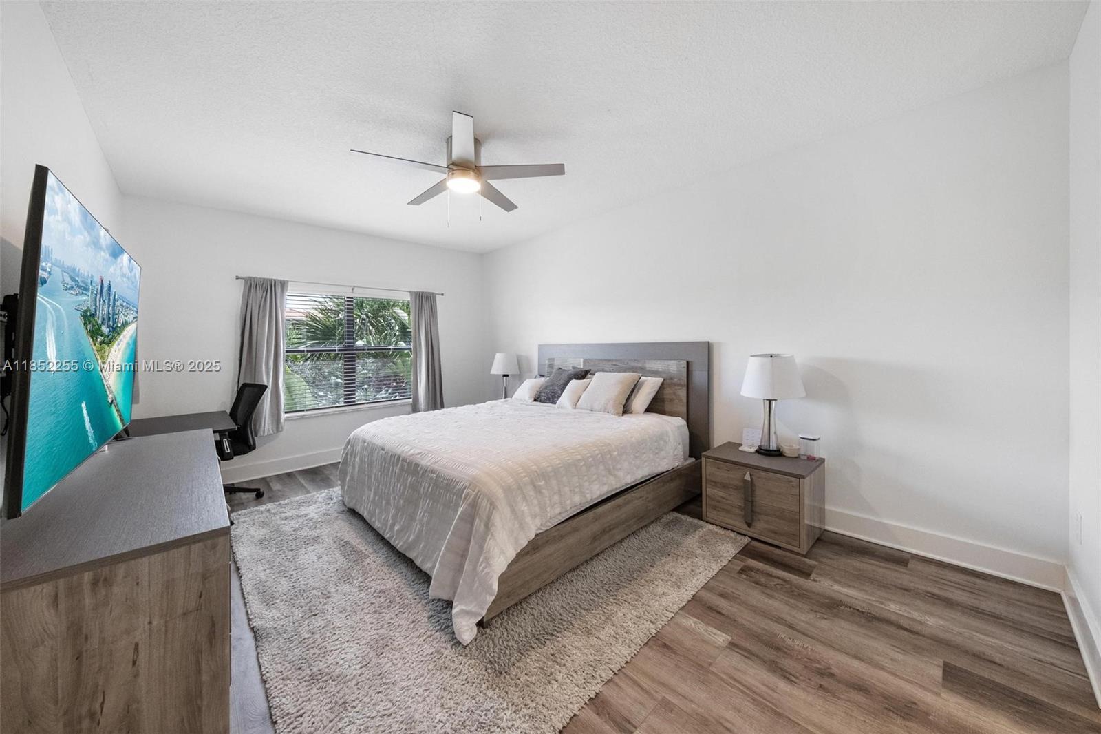 800 Uno Lago Drive, Unit 301 Juno Beach, FL 33408 - Photo 10 of 27 a bedroom with a large bed and a flat tv screen on dresser