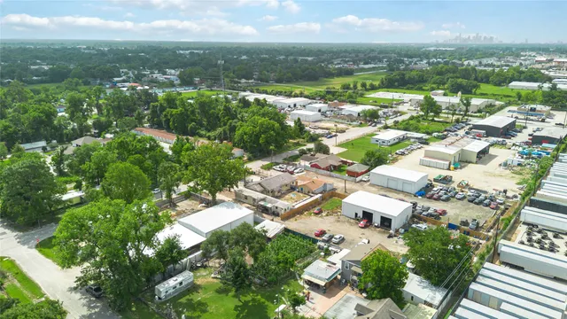 an aerial view of residential houses with outdoor space and trees