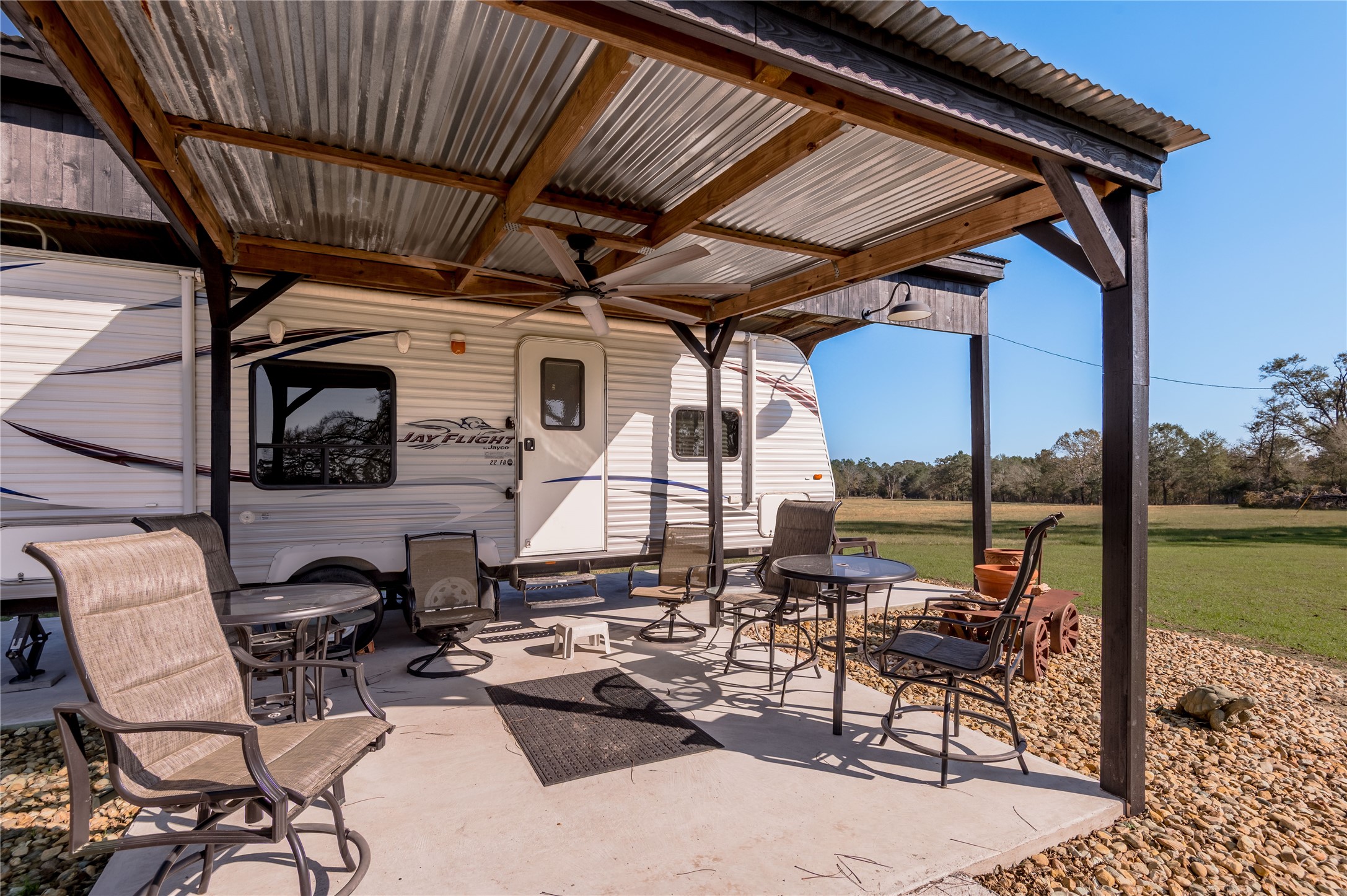 5316 Highway 19 Trinity, TX 75862 - Photo 27 of 34 a view of a patio with table and chairs potted plants and a floor to ceiling window