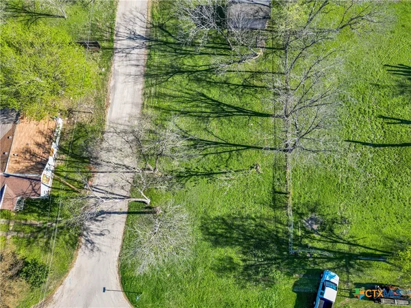 a aerial view of residential houses with outdoor space and trees
