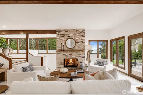 a living room with fireplace furniture and a large window
