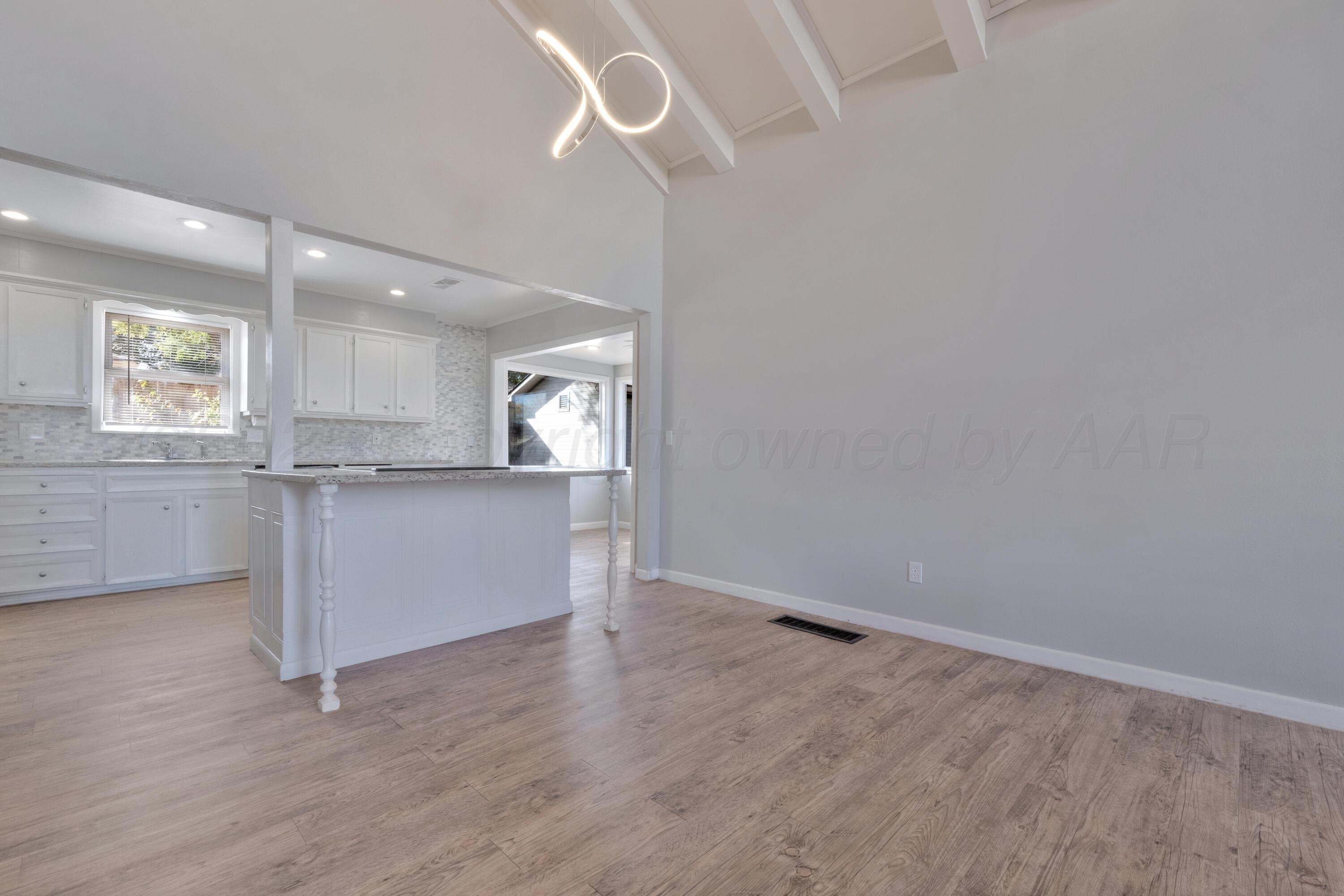 3700 Paramount Boulevard Amarillo, TX 79109 - Photo 11 of 43 an empty room with wooden floor cabinet and windows