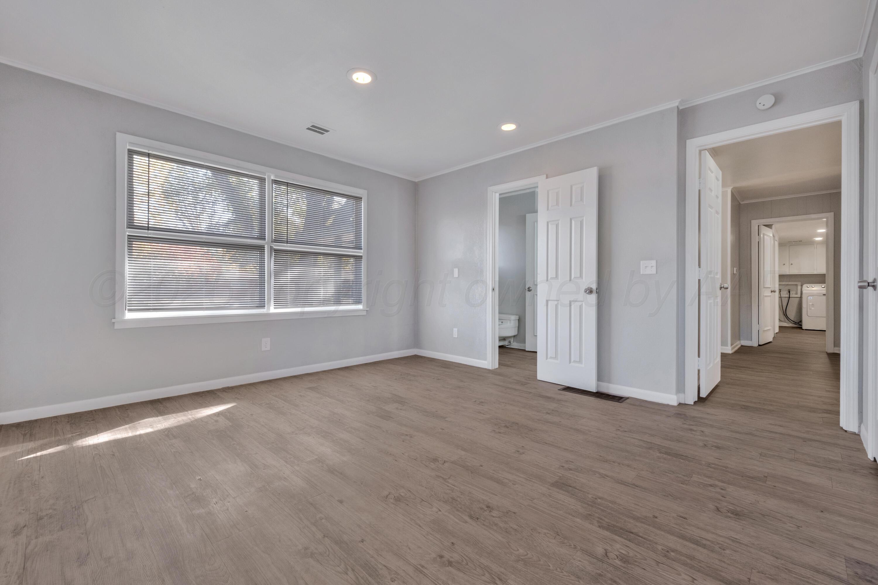 3700 Paramount Boulevard Amarillo, TX 79109 - Photo 21 of 43 an empty room with wooden floor and windows