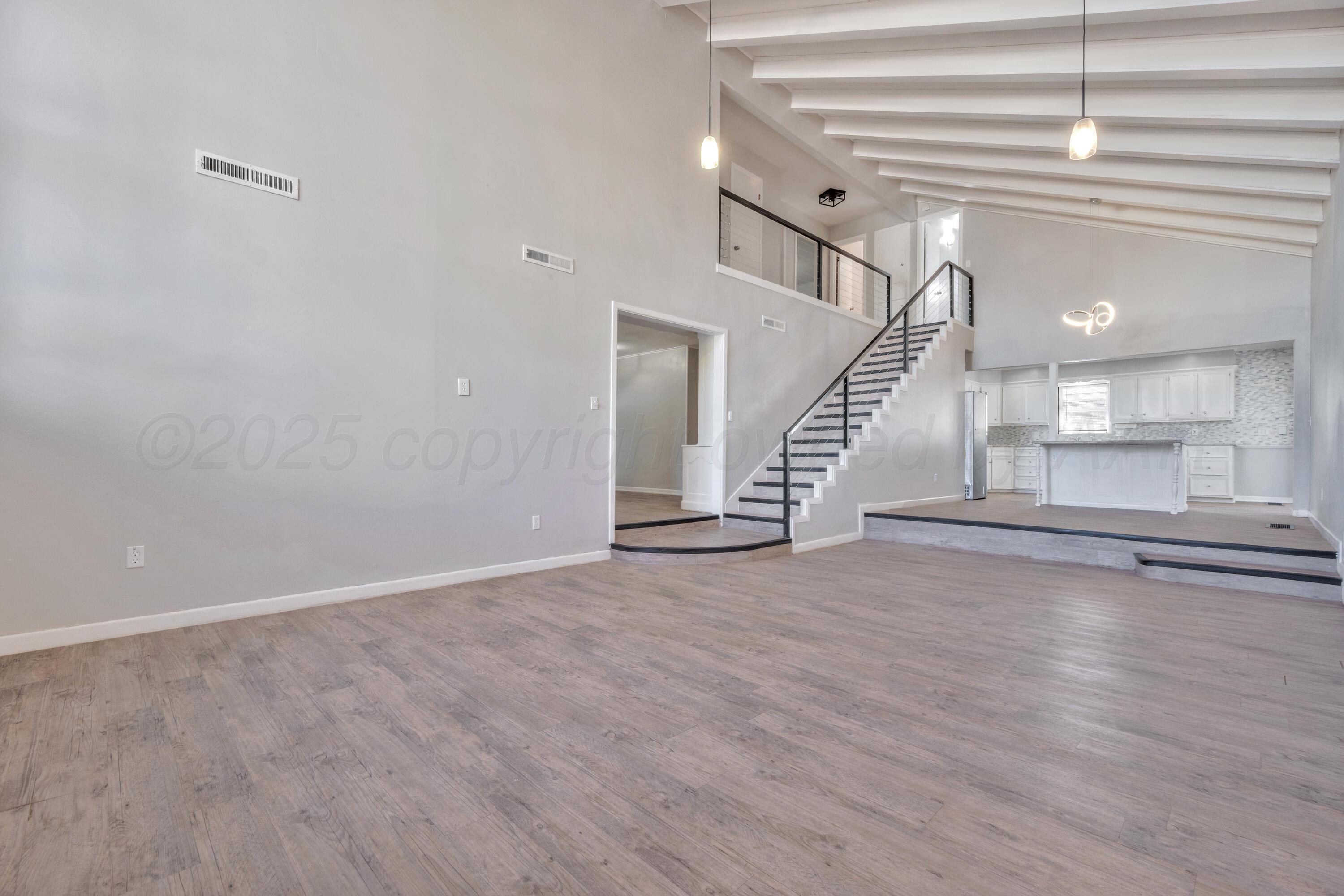 3700 Paramount Boulevard Amarillo, TX 79109 - Photo 9 of 43 a view of an empty room with wooden floor and stairs
