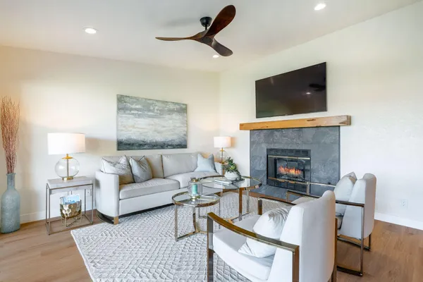 a living room with furniture a flat screen tv and a fireplace
