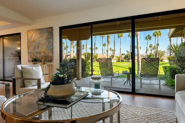a living room with furniture and a floor to ceiling window