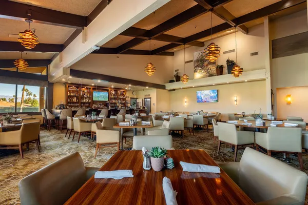 a lobby with furniture and floor to ceiling window and potted plants