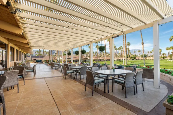 a view of a patio with a table chairs and a garden