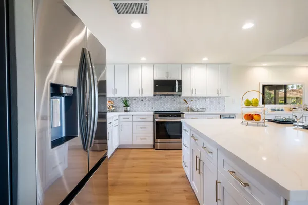 a kitchen with a sink a counter top space stainless steel appliances and cabinets