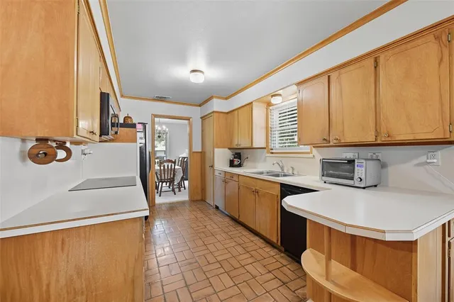 a kitchen with a sink appliances and cabinets