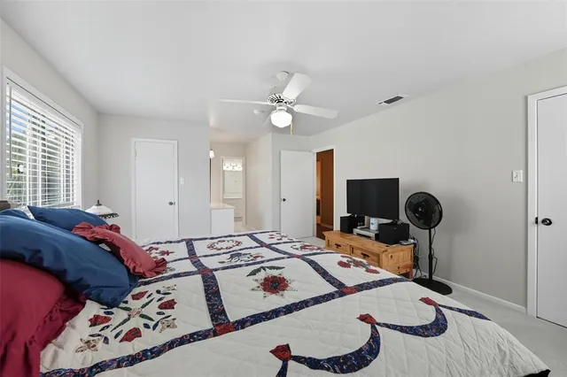 a bedroom with a bed and a table with potted plants