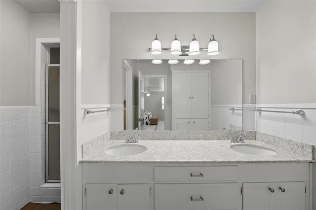 a bathroom with a double vanity sink and a mirror