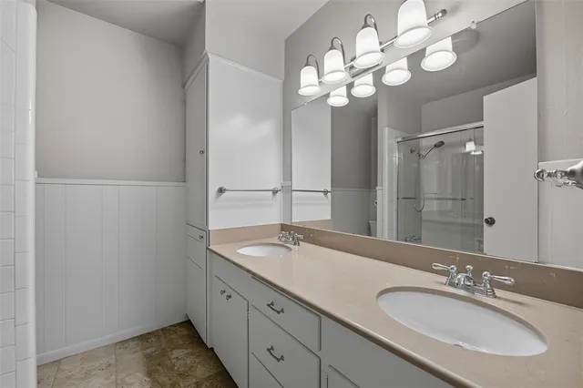 a bathroom with a granite countertop sink a large mirror and a shower
