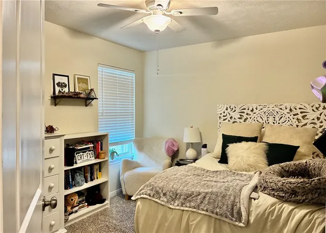 a bedroom with a bed and a ceiling fan