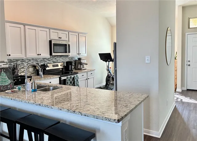a kitchen with stainless steel appliances granite countertop a sink and cabinets
