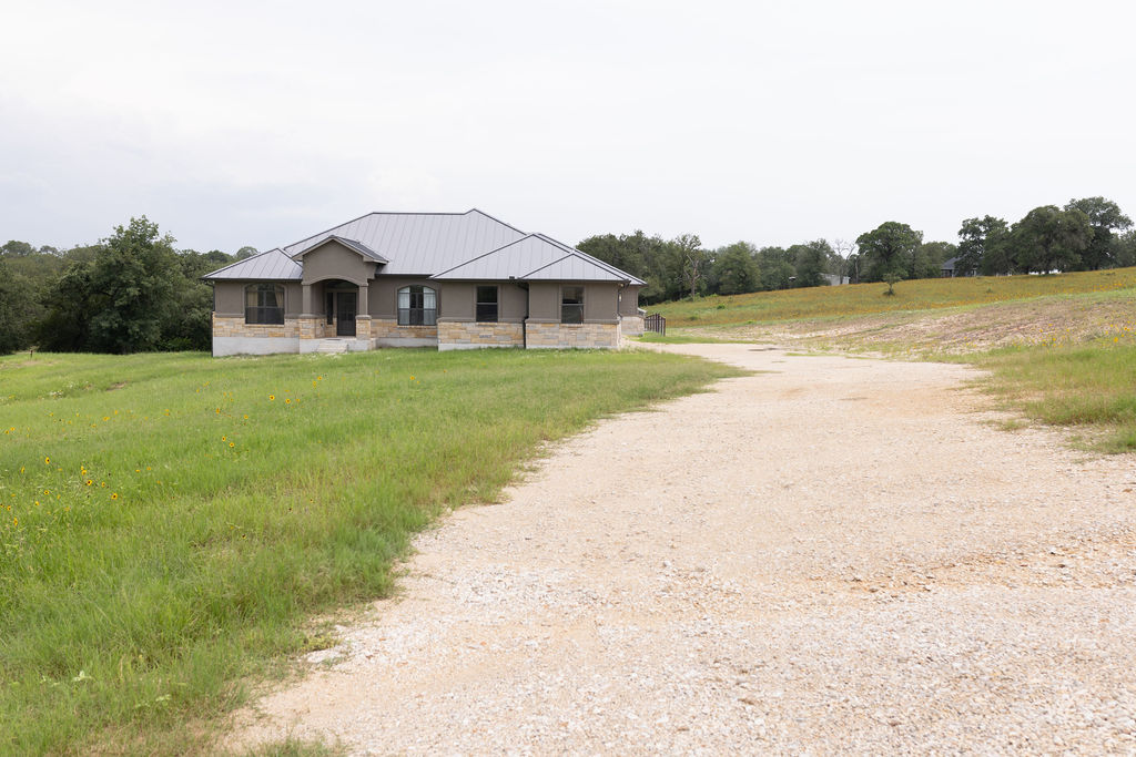 111 Powder Ridge Luling, TX 78648 - Photo 18 of 22 A graceful home nestled in a generous landscape with a long, inviting gravel driveway.