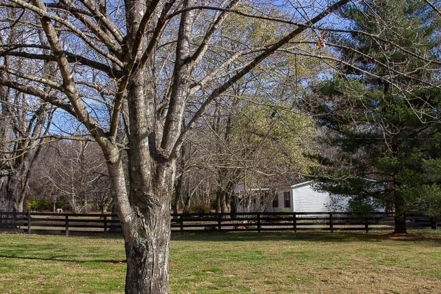 a view of a house with backyard and trees