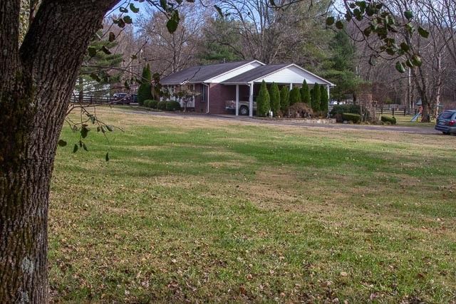 a view of a house with a swimming pool and a yard with furniture