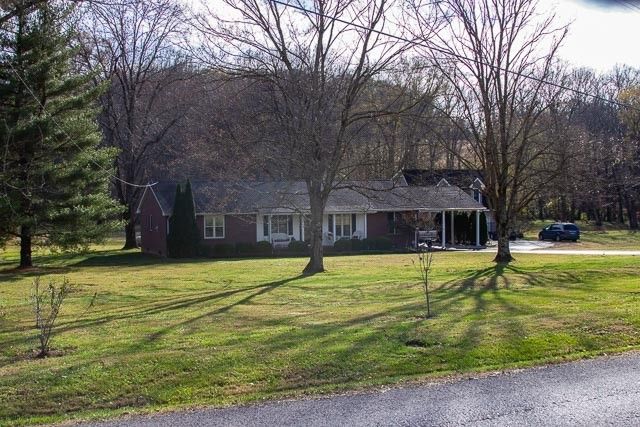 a kitchen with stainless steel appliances granite countertop a stove a sink dishwasher and a refrigerator with wooden floor