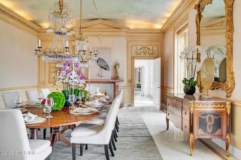 a view of a dining room with furniture a chandelier and wooden floor