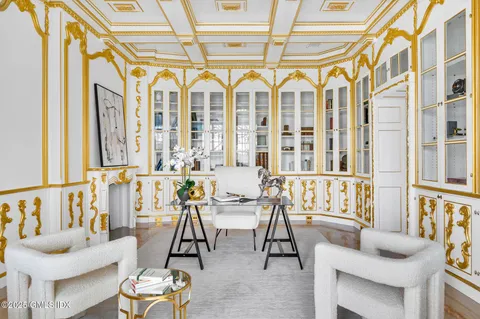 a living room with couches a table and chairs with wooden floor