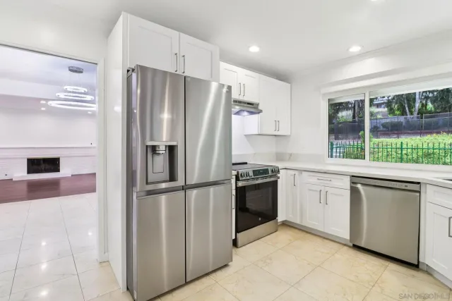 a kitchen with stainless steel appliances granite countertop a refrigerator and a sink