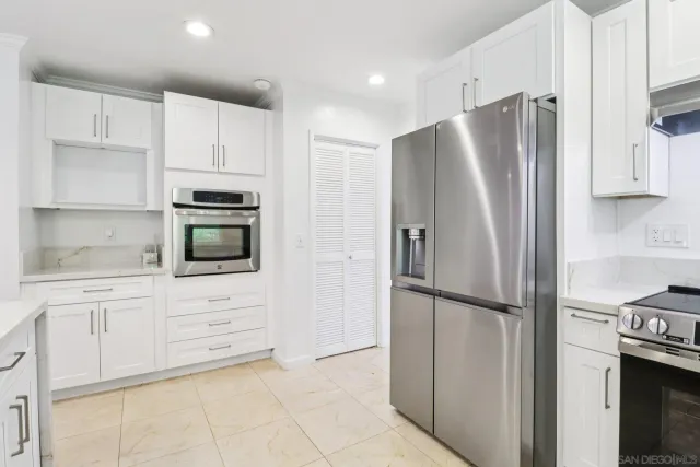 a kitchen with granite countertop a refrigerator and a stove top oven