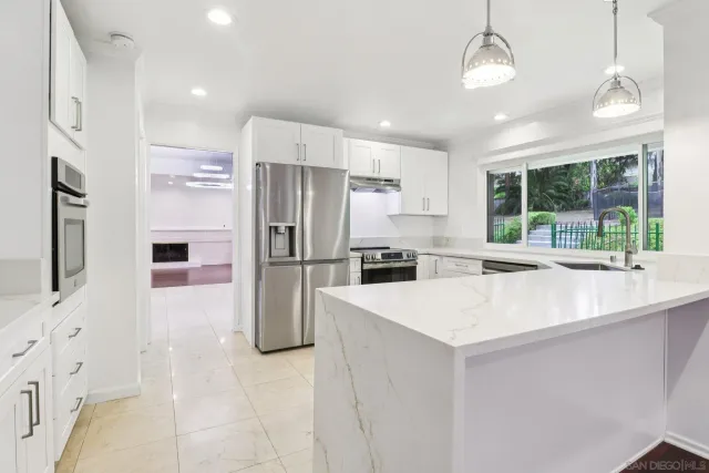a kitchen with stainless steel appliances a refrigerator sink and microwave