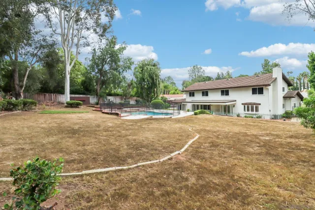 a view of a house with a backyard and trees
