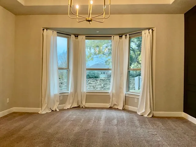 an empty room with windows lake and mountain view