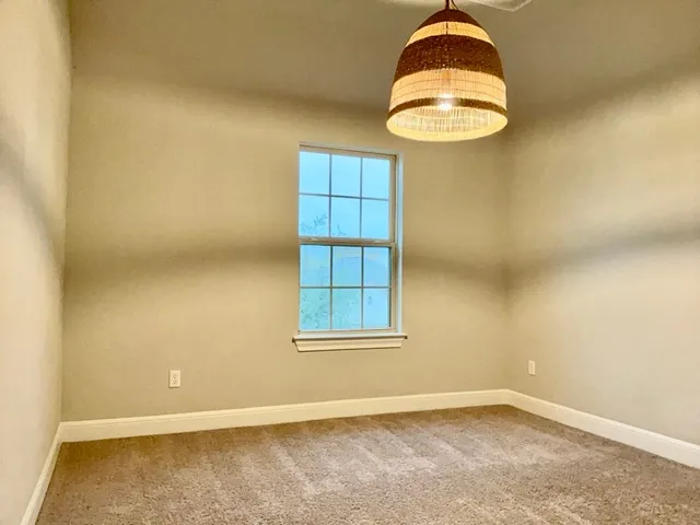 an empty room with windows and chandelier