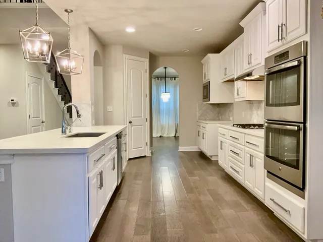 a kitchen with granite countertop a sink stainless steel appliances and cabinets